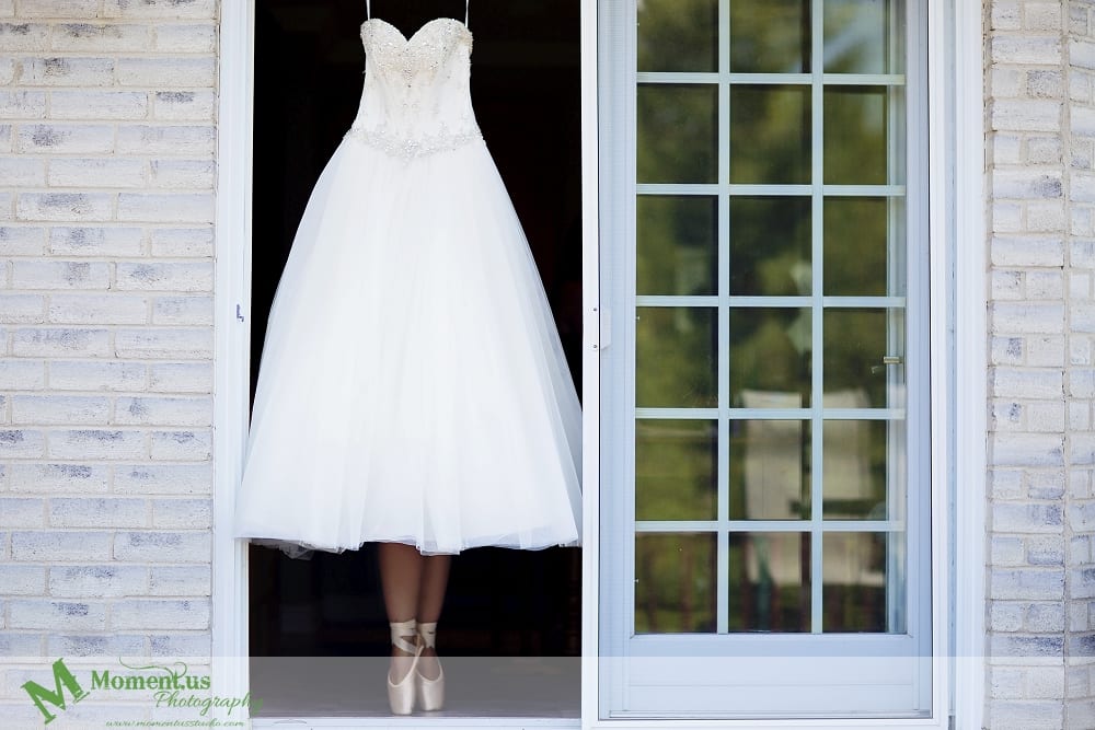 elegant Cornwall wedding - wedding dress hanging in doorway pointe shoes underneath