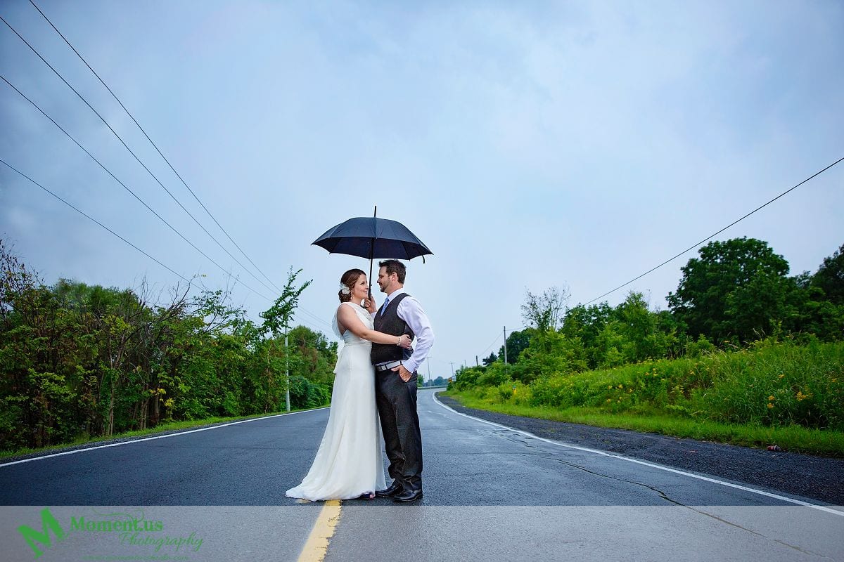 Cornwall weddings - Couple standing on road with umbrella