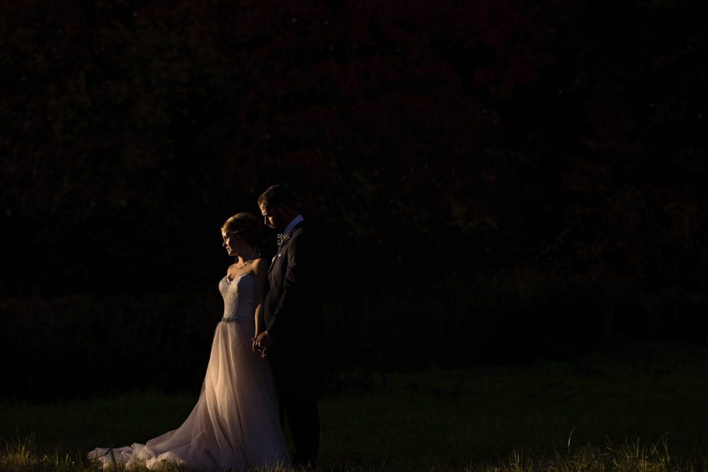 bride and groom facing sun in deep shadows during Cornwall wedding