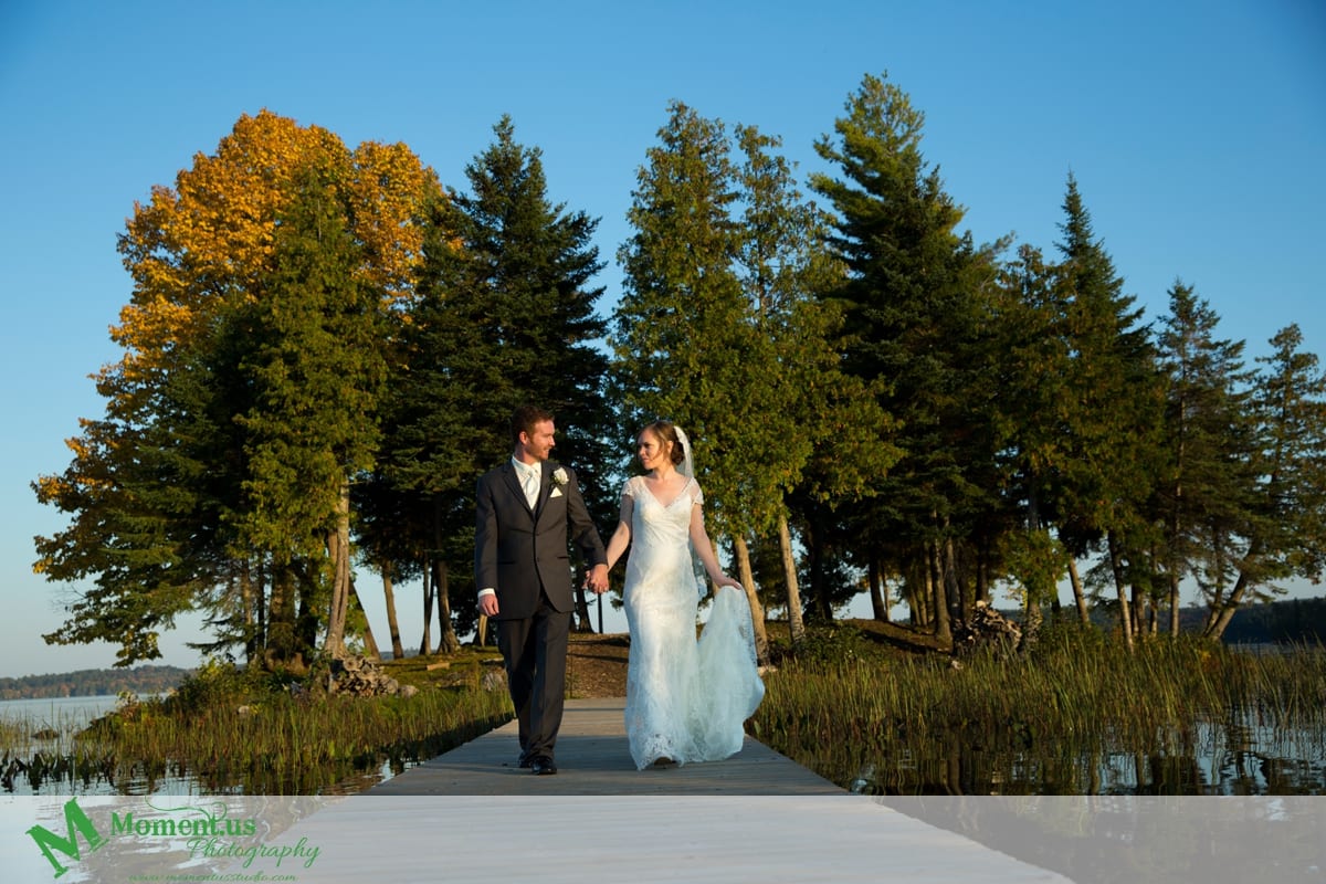 bride and groom walking across wooden bridge - Calabogie Peaks Wedding
