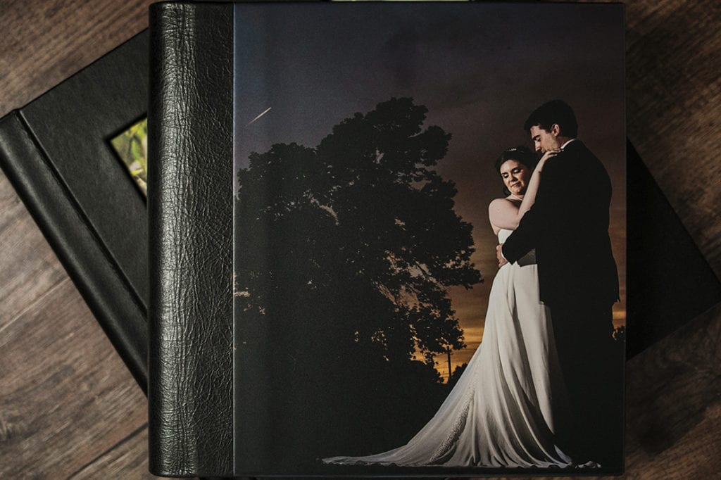 cover of Modern Ontario Wedding Album featuring couple cuddling at sunset with tree shadowed in background