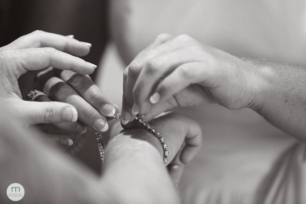 bride helping bride with bracelet