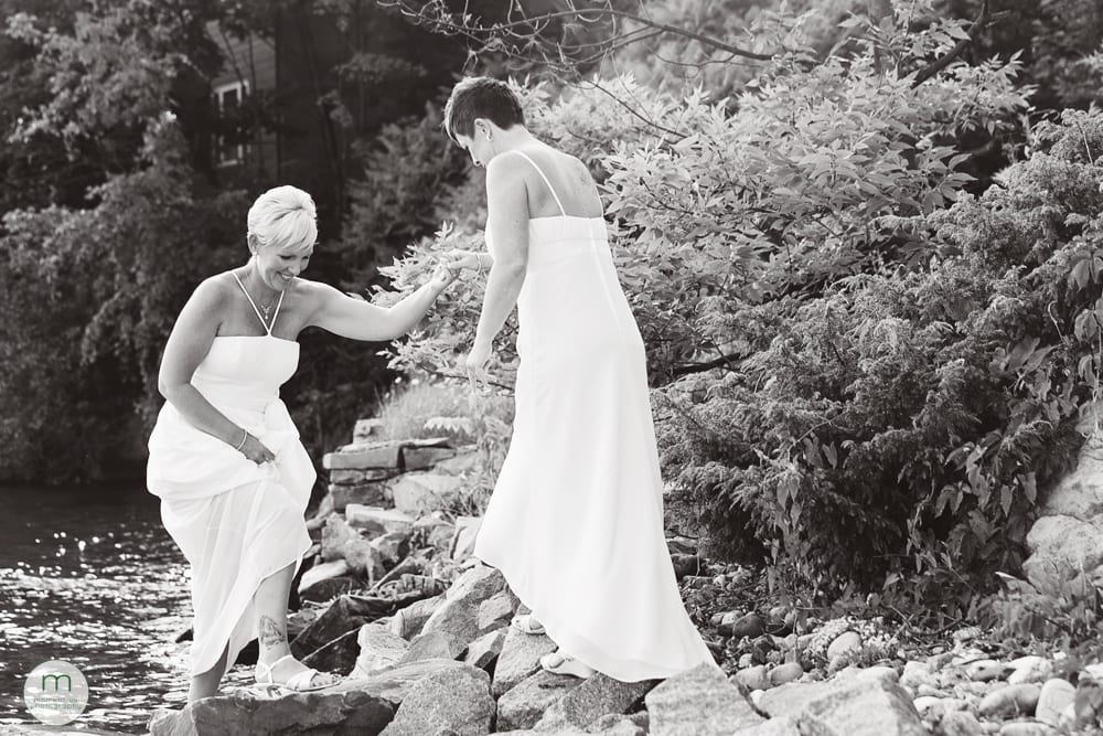 2 brides by river on rocks