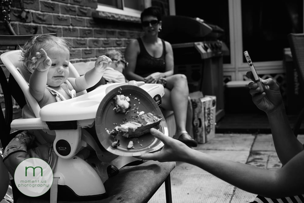 boy pushing cake off highchair