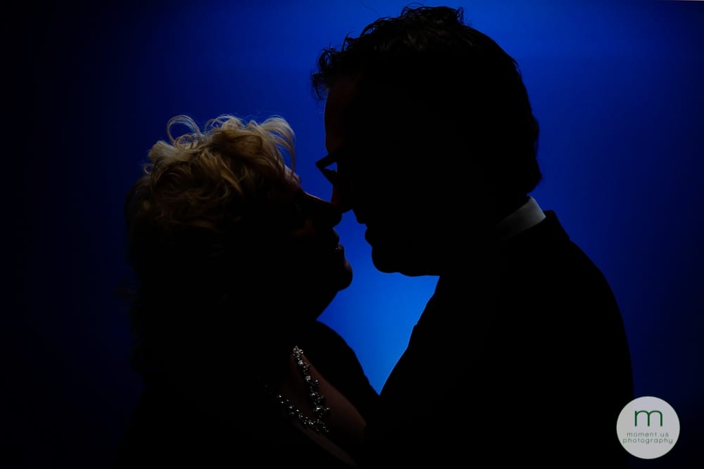 man and woman nose to nose blue wall