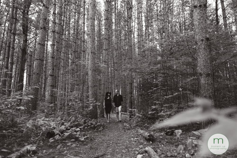 pregnant woman and husband walking through forest