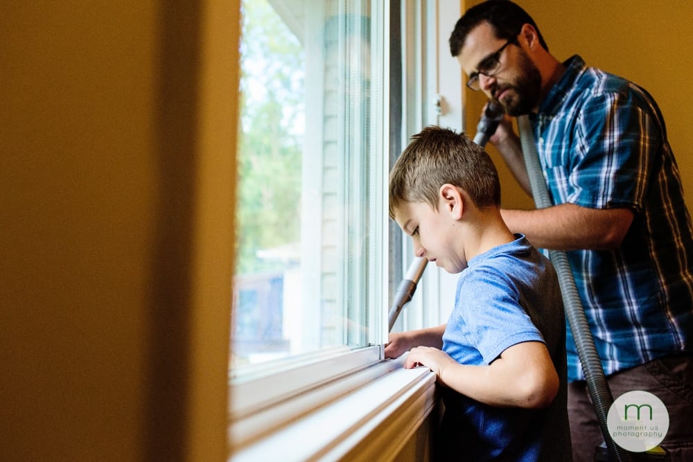 boy and dad vacuuming window