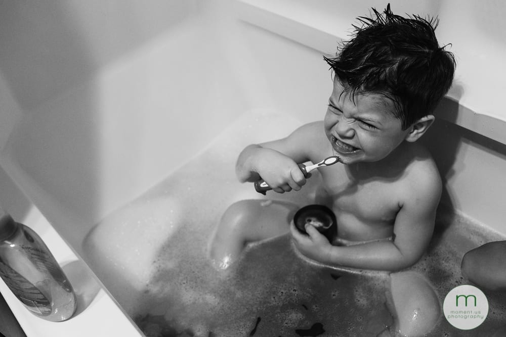 boy brushing teeth in tub