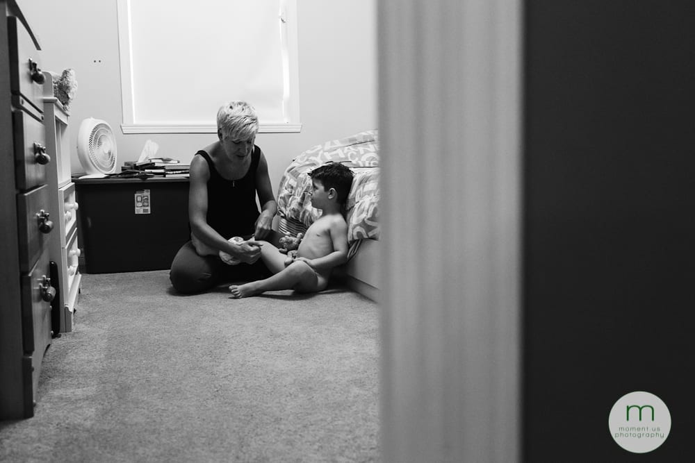 mom helping boy put pyjamas on