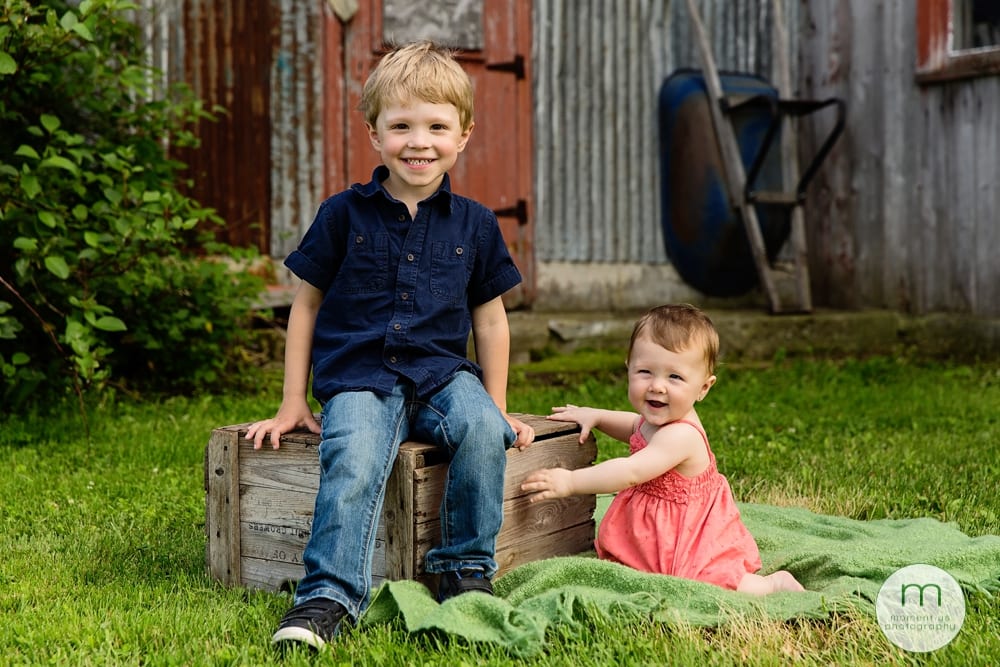 boy and girl on green blanket