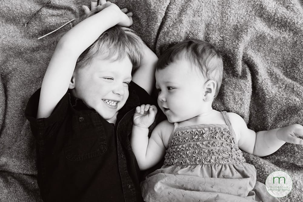 boy looking at sister on backs