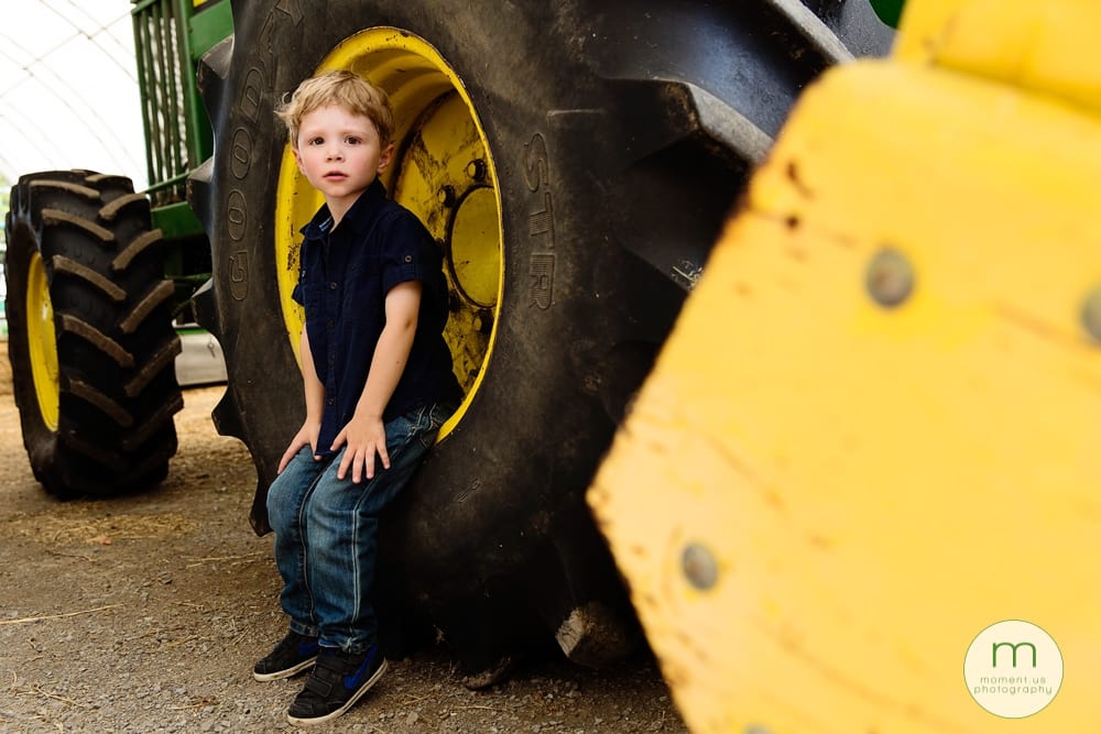 boy sitting on truck wheel