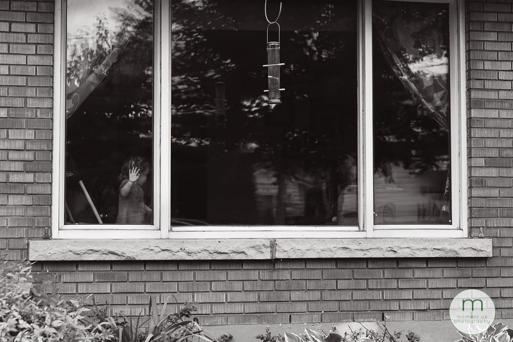girl with hand on window