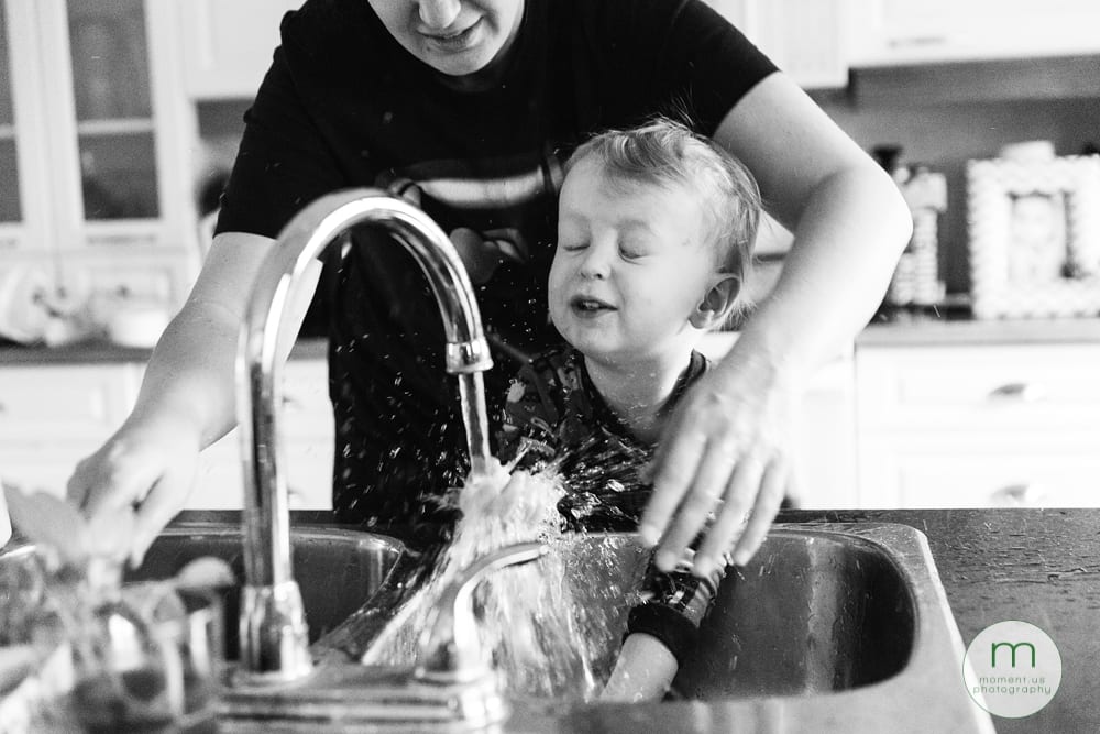 boy splashing face at sink