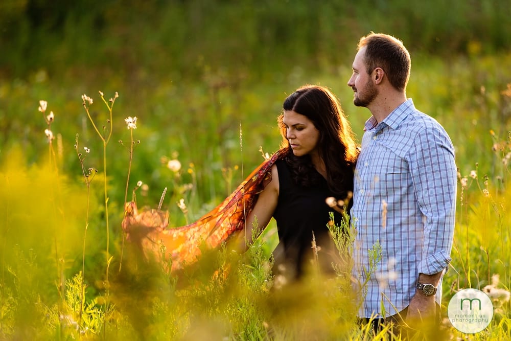 couple standing in tall grass with scarf
