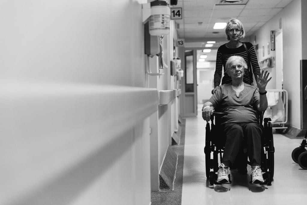 daughter pushing mother in wheelchair