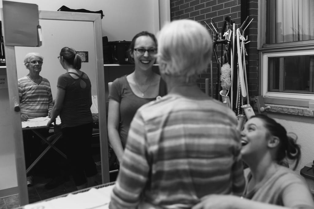 therapist laughing with patient on bed