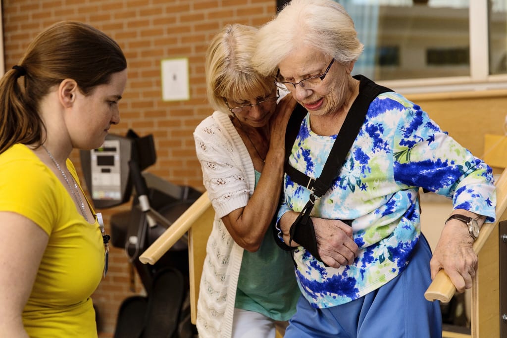 daughter helping mother on stairs