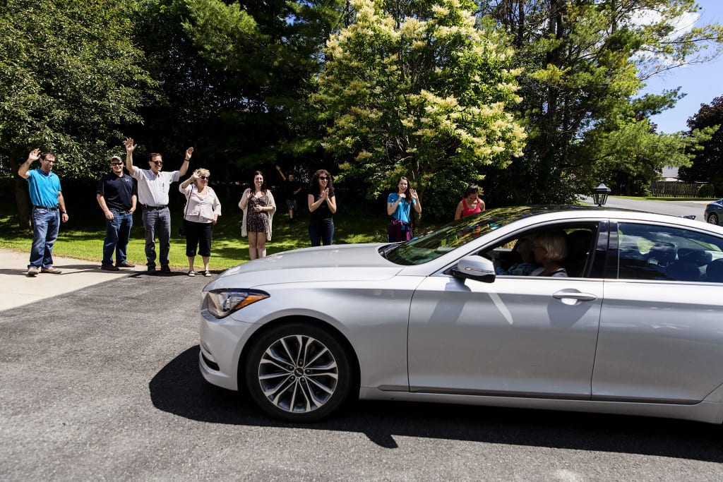 family waving at car