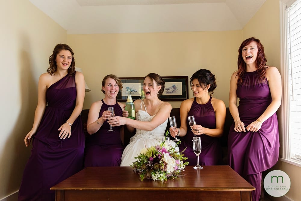 bride laughing with bridesmaids on couch