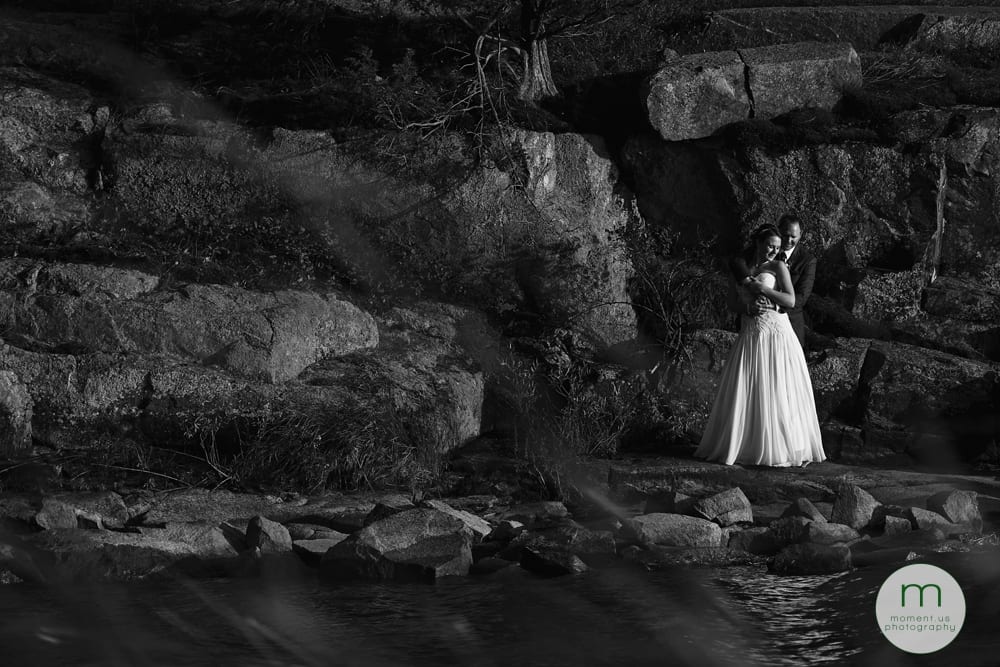 bride and groom on rocky outcrop in bay