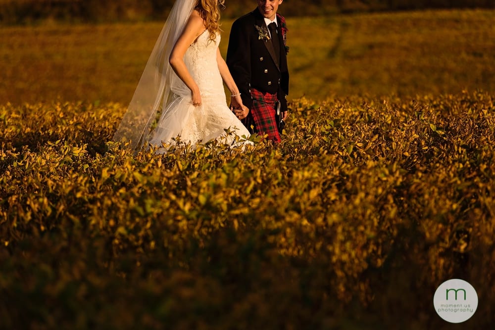 Cornwall Rustic Country Wedding - bride holding dress up in soy field