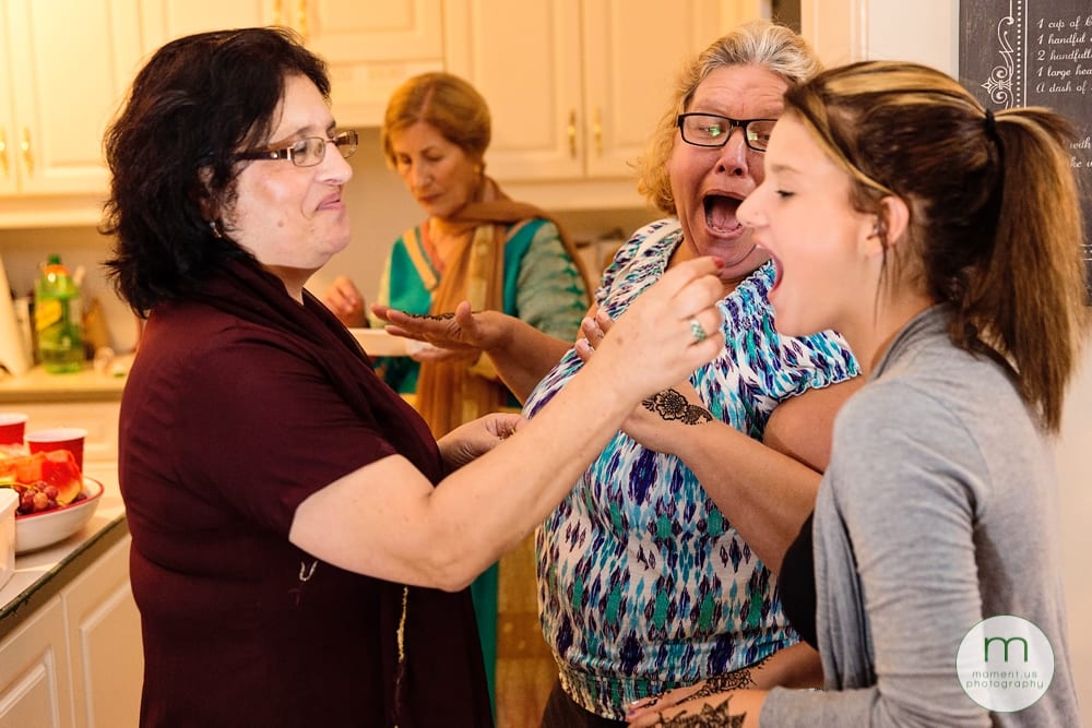 groom's mother feeding guests during mehndi