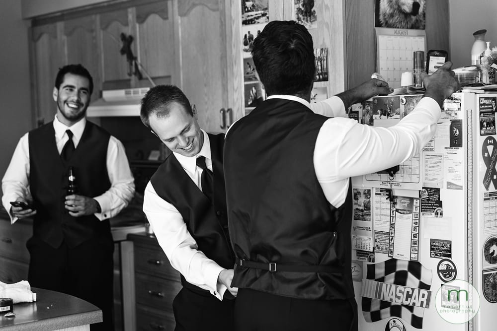 groomsman pinning groom's vest