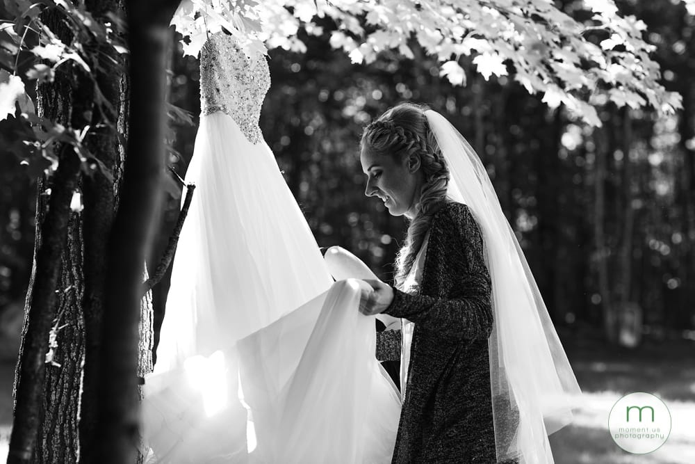 bride adjusting dress in forest