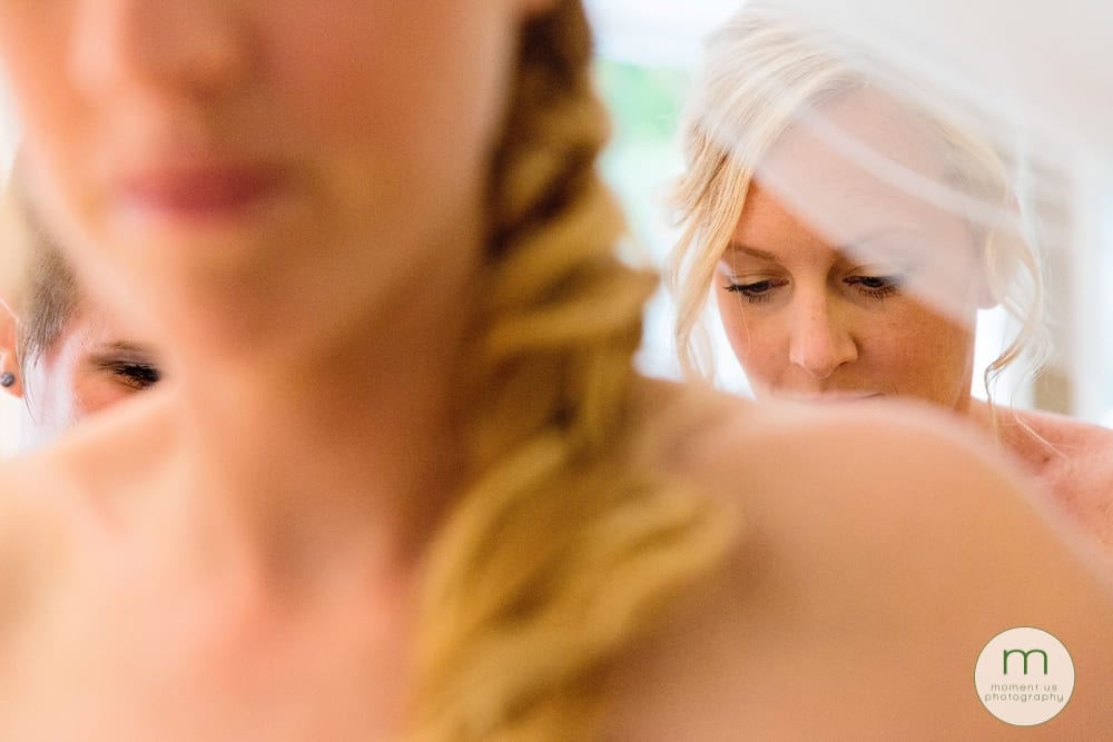 bridemaids doing up dress