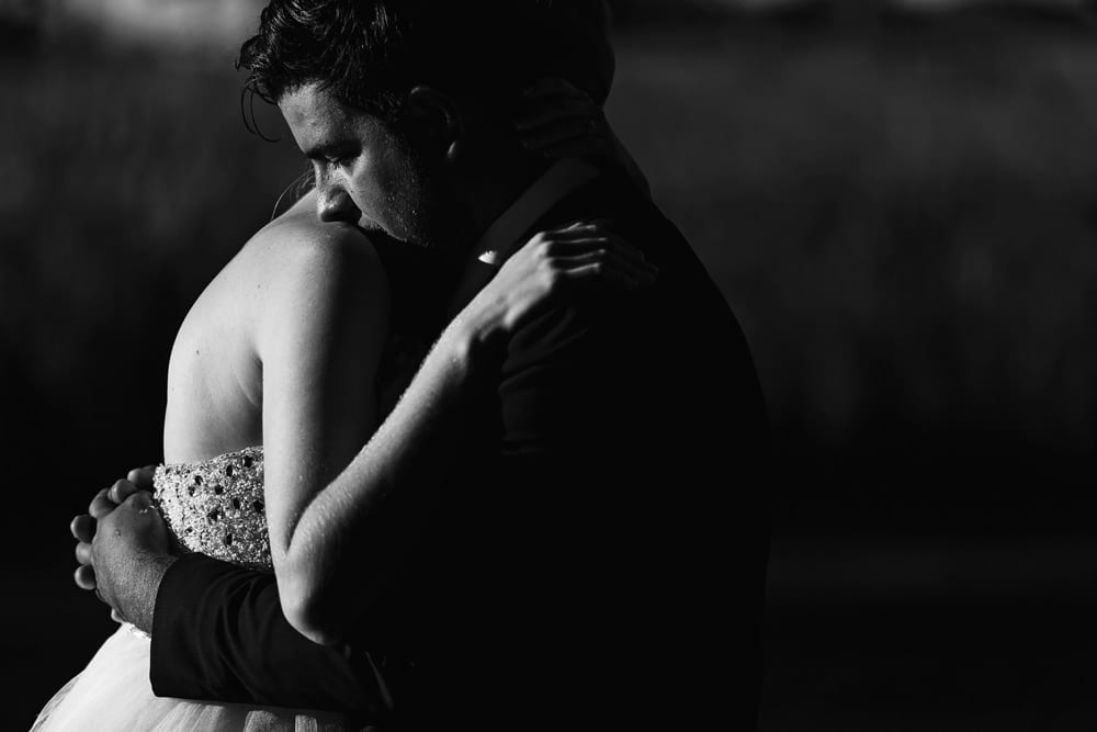 groom kisses bride on the shoulder