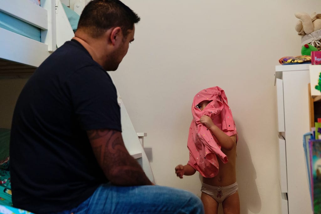 dad helping daughter get dressed