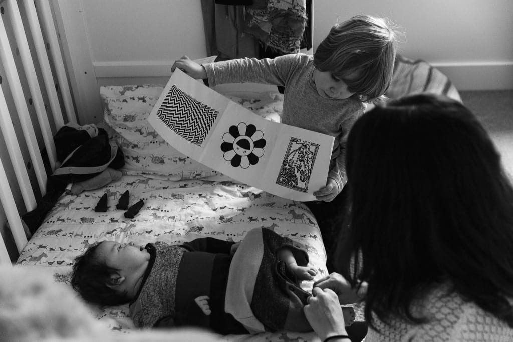 London brother showing baby a book