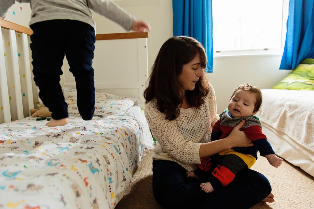 London boy jumpin gon bed next to mom and brother