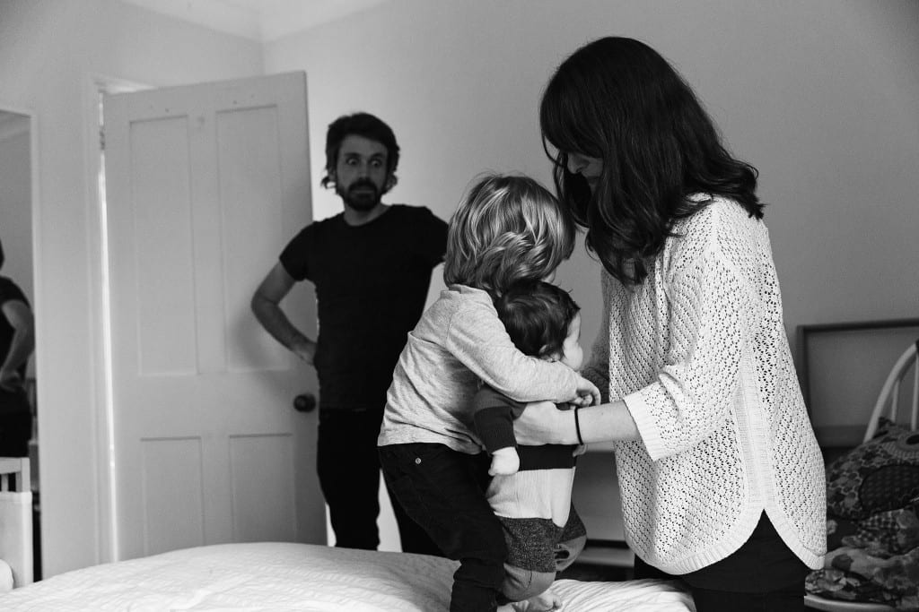 London family teaching brother to hold baby