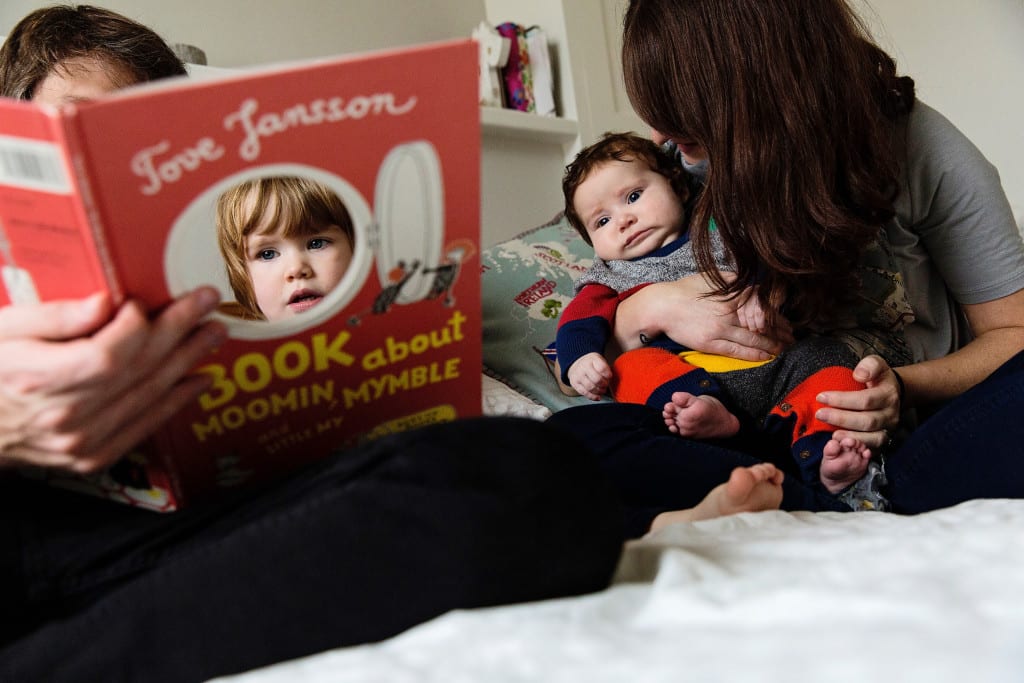 London family reading on bed