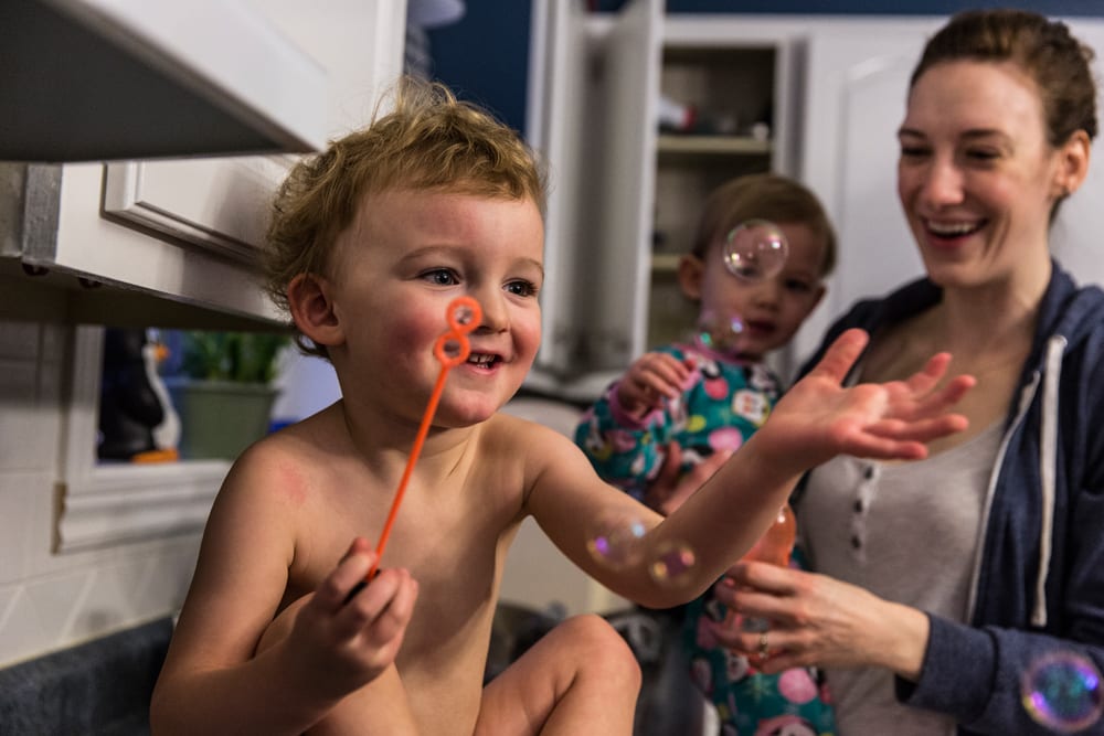 Cornwall family photography - blowing bubbles in the kitchen