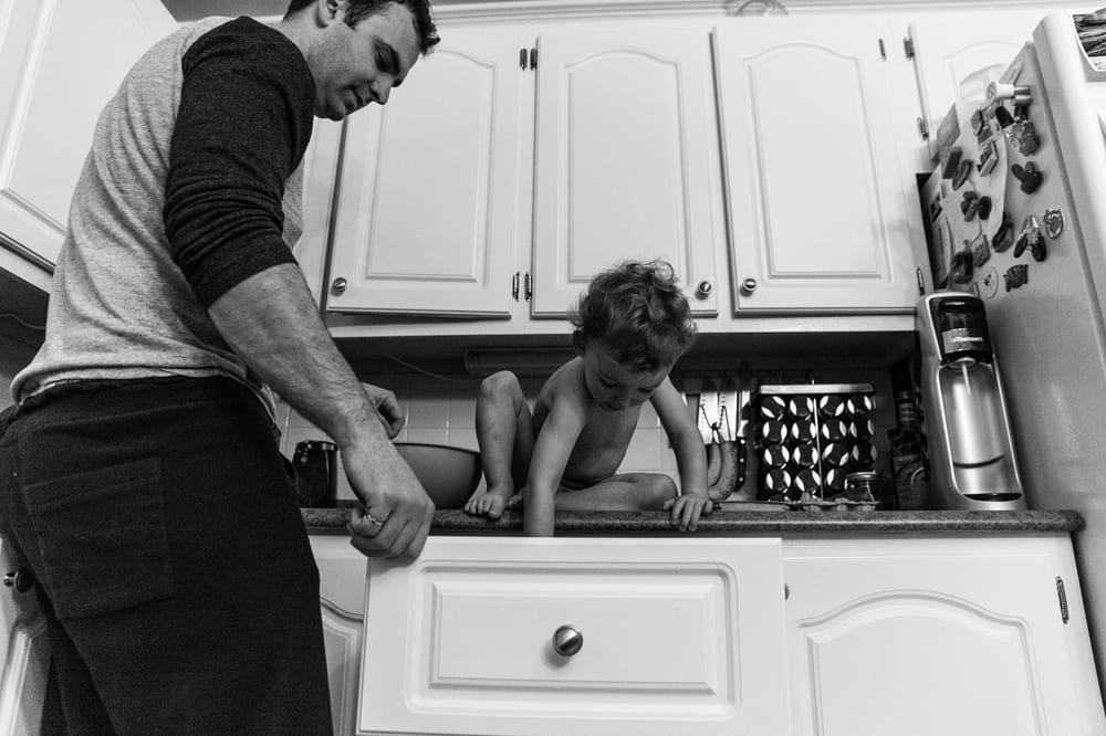 Cornwall family photography - boy sitting in counter digging in drawer