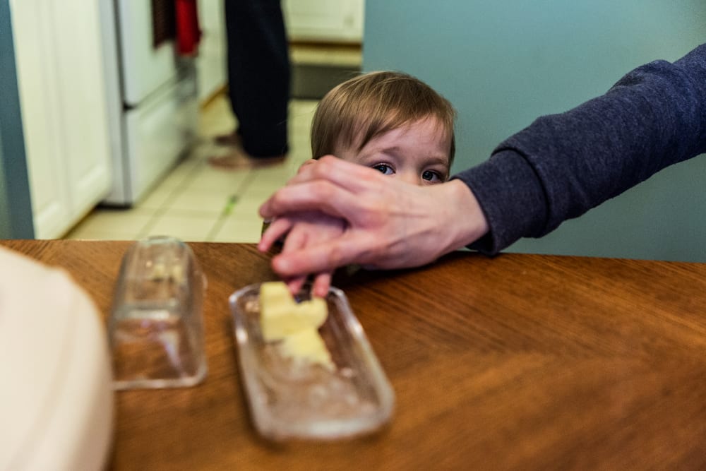 Cornwall family photography - girl caught with finger in butter