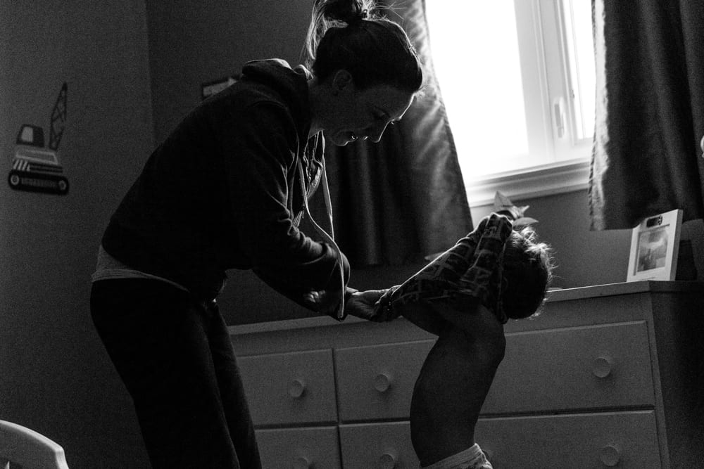 Cornwall family photography - mom getting son dressed