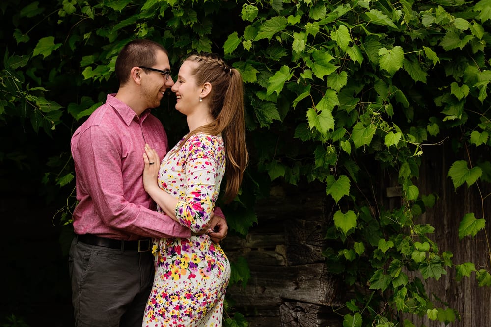 Ontario wedding photographer - couple cuddling for Cornwall engagement photos next to family barn