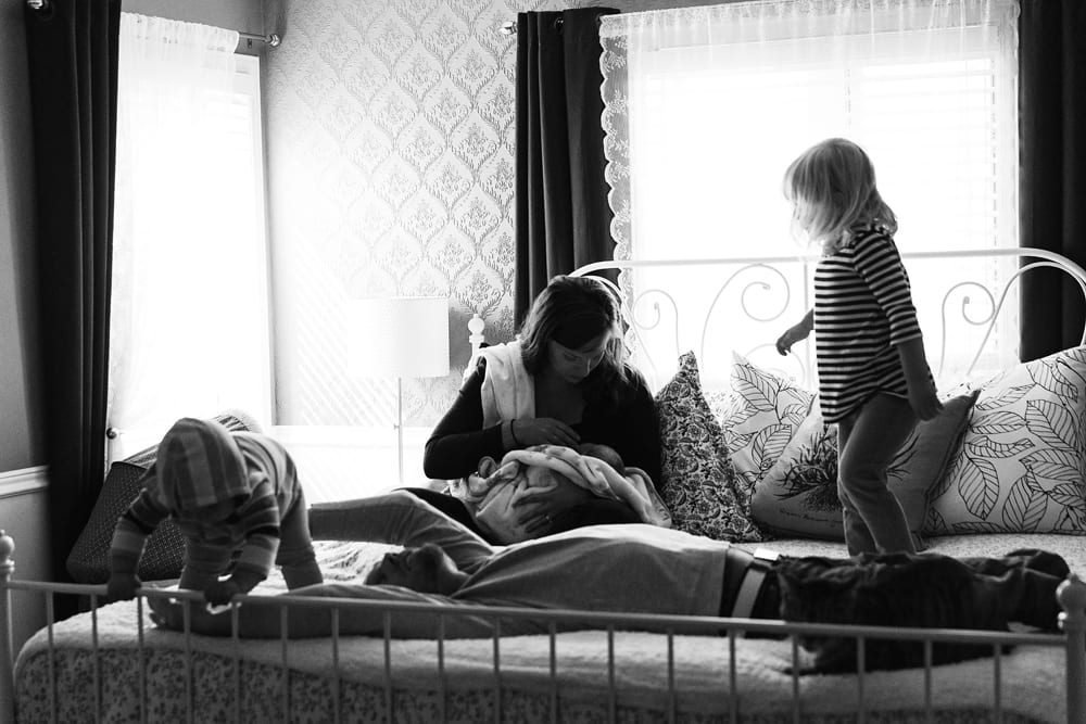 Cornwall family photographer - family playing on bed