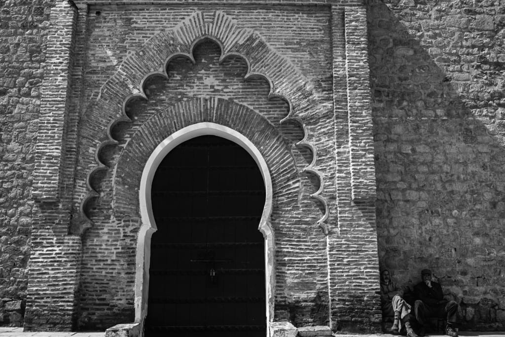 Wedding photographer in Morocco - men sitting outside Koutoubia mosque