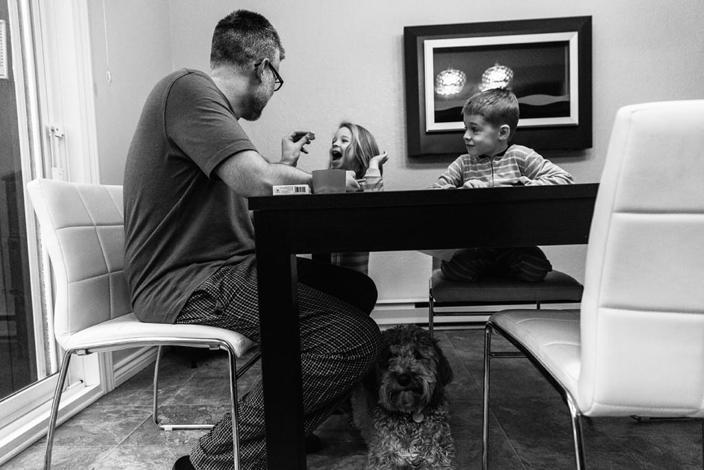 portrait of dad with children and dog at breakfast table