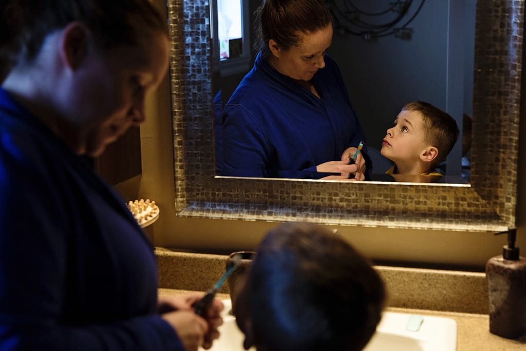 mom helping son brush teeth