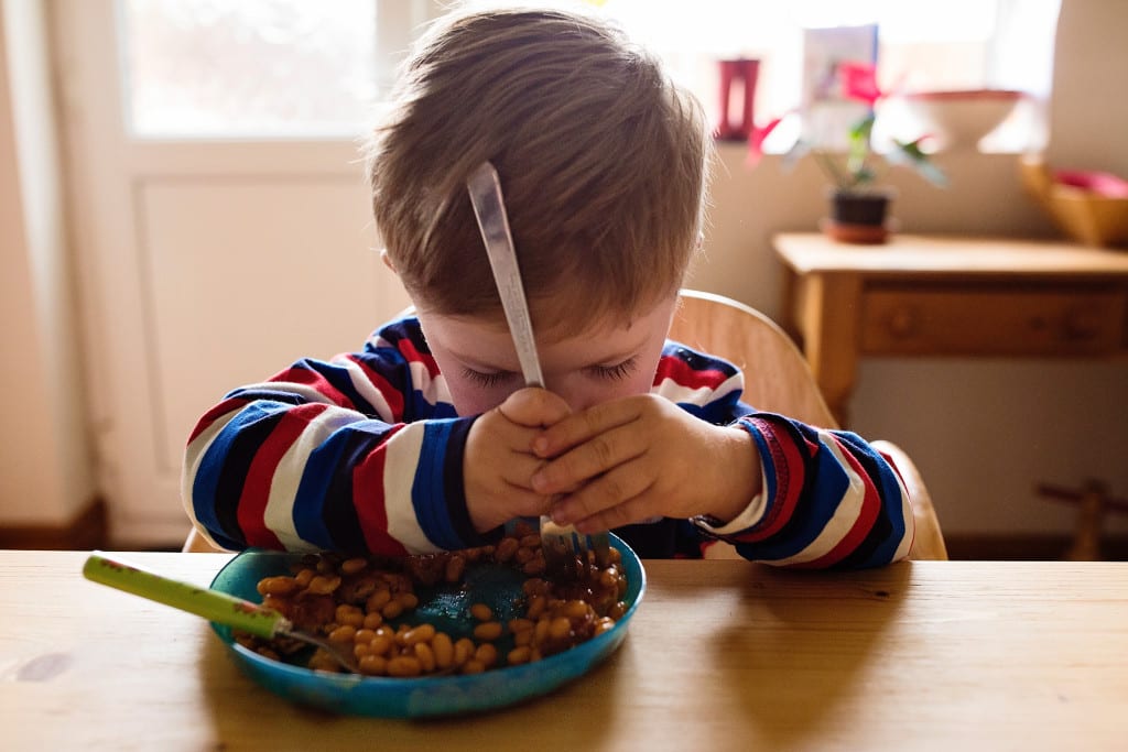 boy eating beans during session with South Wales family photographer