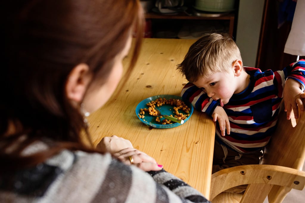 boy looking torn about food choice during South Wales family session