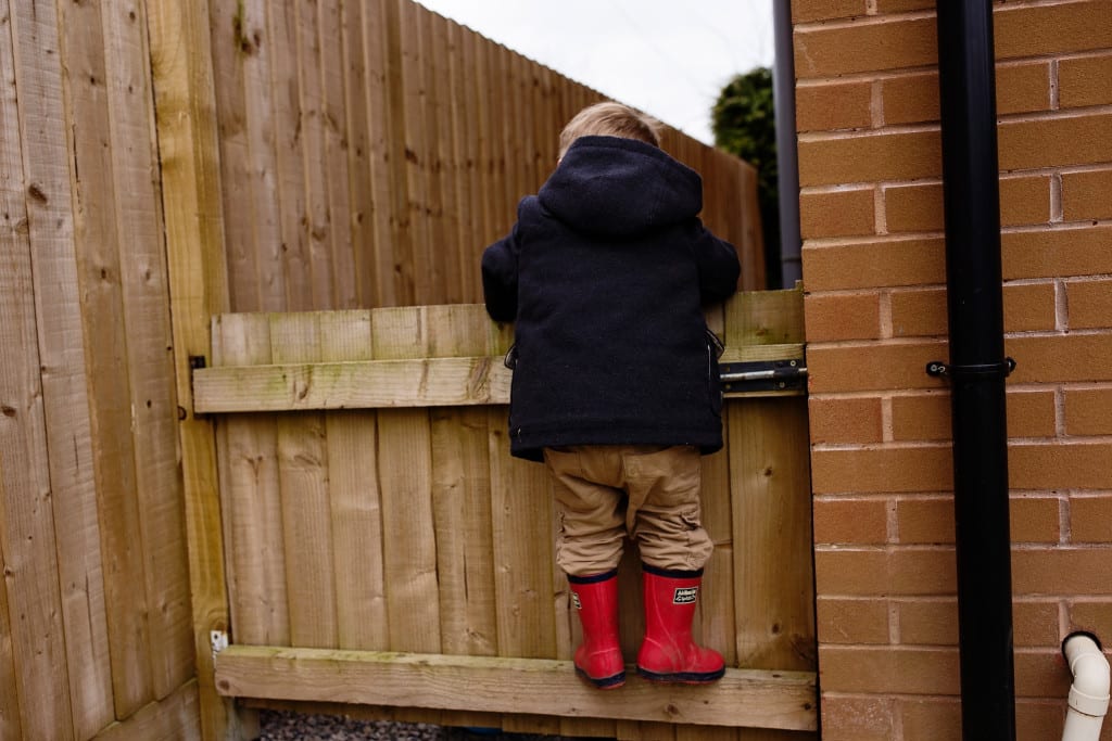 boy standing on gate