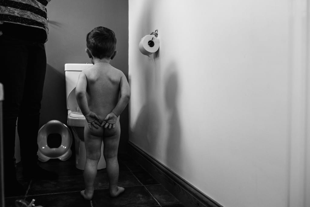 boy looking at toilet during South Wales family session