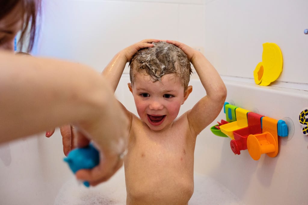 boy excited about bath toys during South Wales family session